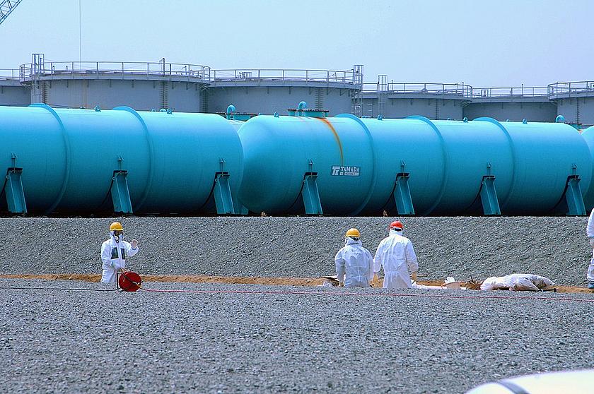 Angestellte von Tepco arbeiten im April 2013 an den unterirdischen Wasserspeicherbecken des Kernkraftwerks Fukushima Daiichi. Im Hintergrund erheben sich zwei Arten von oberirdischen Lagertanks. 
