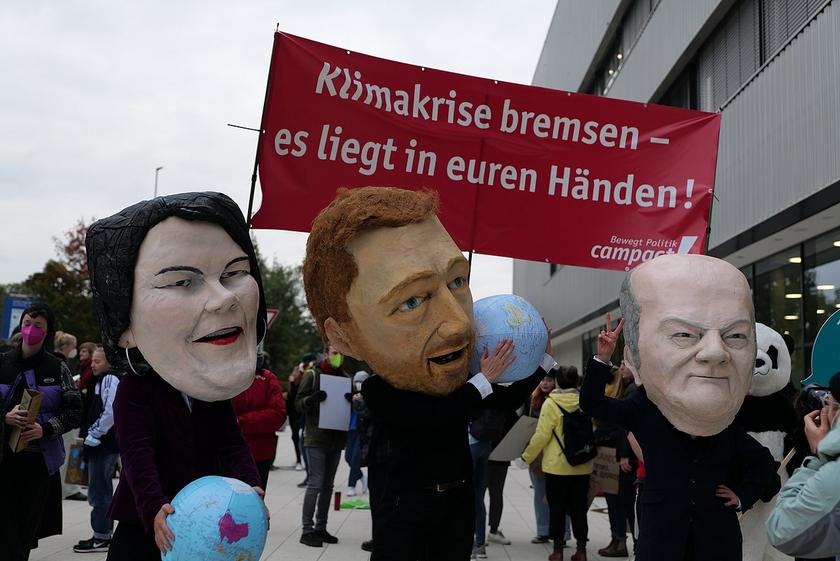 Karikaturen von Baerbock, Scholz und Lindner bei einer Demo.