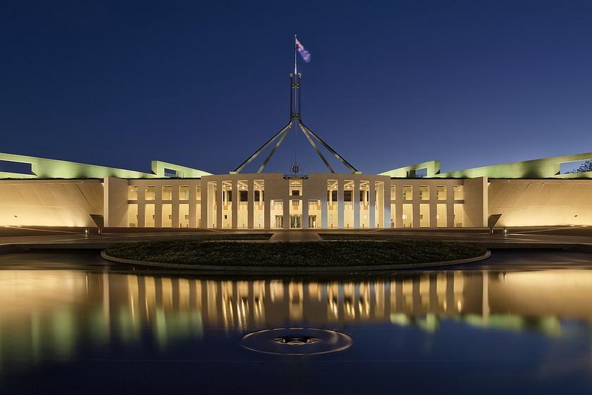 Das Parlament Australiens. ein langgezogenes beleuchtetes Gebäude in der Abenddämmerung