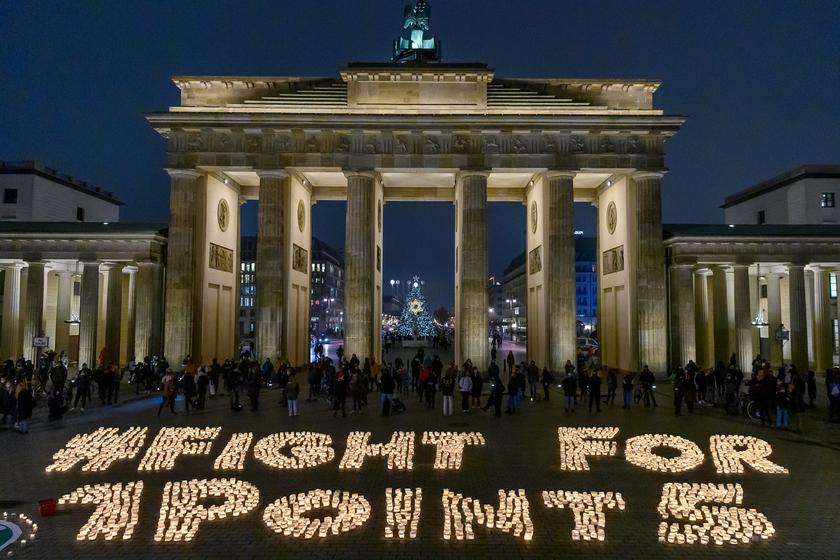Kerzen vor dem Brandenburger Tor in der Dunkelheit, die "Fight for 1 Point 5" bilden. 5