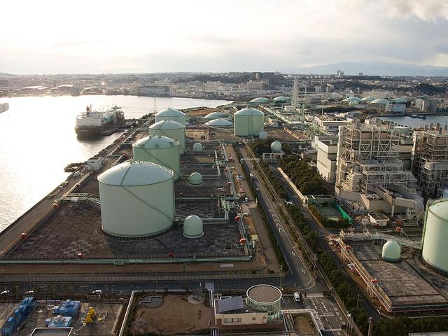Luftaufnahme eines LNG-Terminals mit Gasspeichern am Wasser.