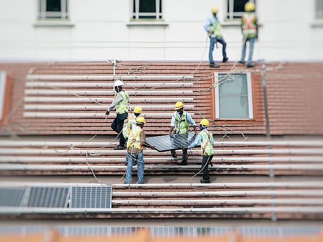 Arbeiter installieren eine Solardachanlage