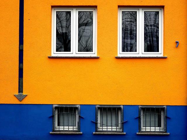 Orange-Blaue Hausfassade mit modernen Fenstern