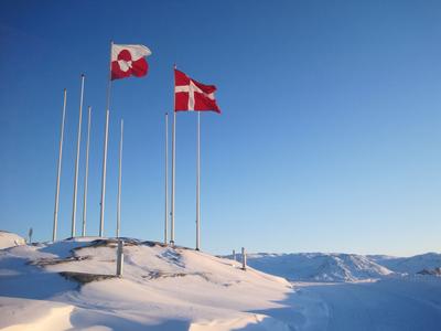 Flaggen von Grönland und Dänemark im Schnee.