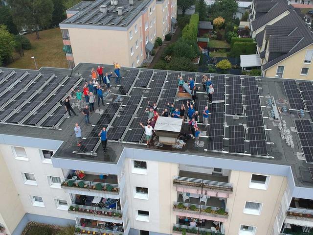 Menschen auf Flachdach mit PV-Anlage