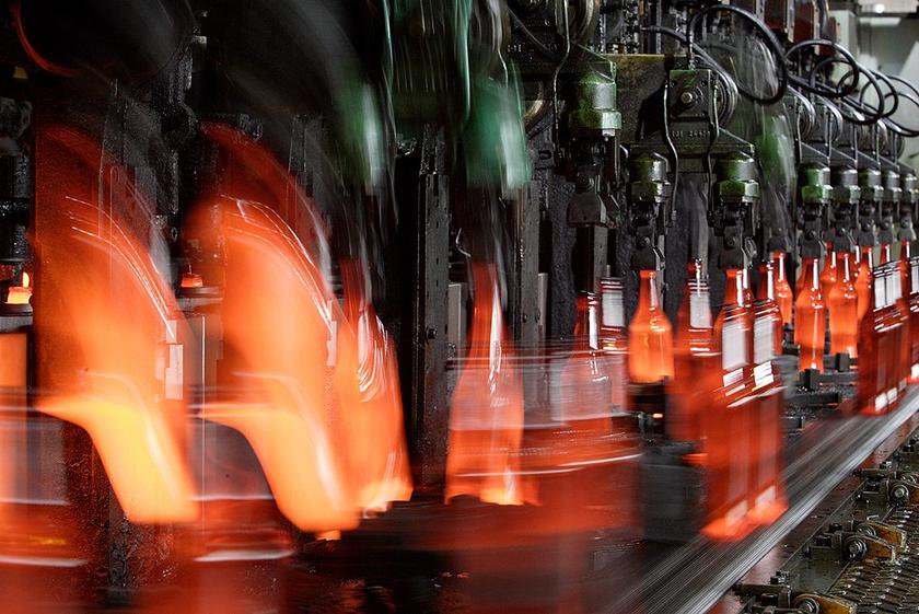Industriemaschine, die Glasflaschen formt, das Glas ist flüssig orange