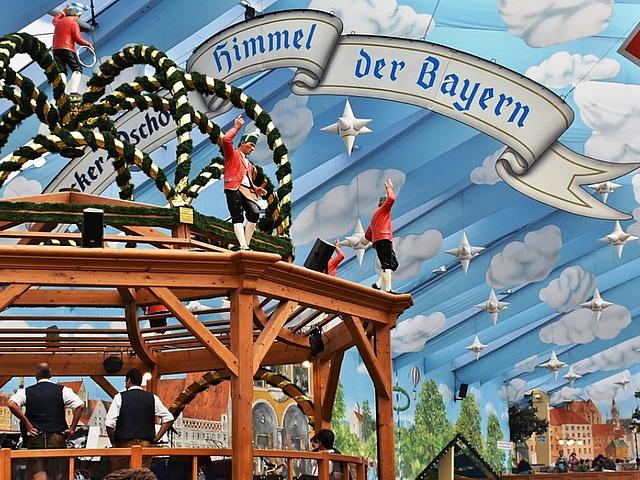 Im Bierzelt auf dem Oktoberfest in München – an der Decke die Aufschrift „Der Himmel über Bayern“