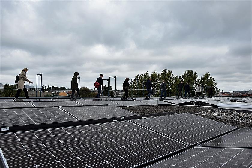 Menschen auf auf einem Dach mit Photovoltaikanlage