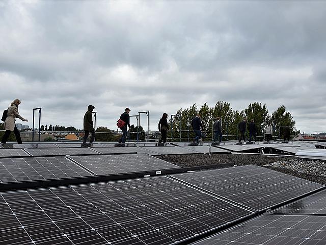 Menschen auf auf einem Dach mit Photovoltaikanlage