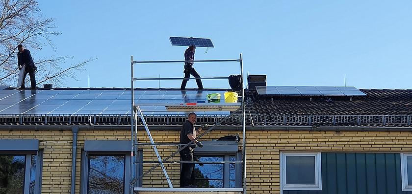 Arbeiter demontieren eine Solaranlage