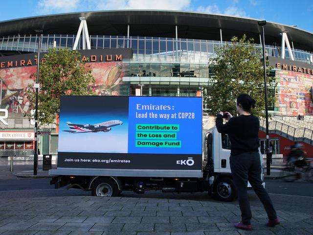 Auto mit Banner vor dem Emirates Stadion in London