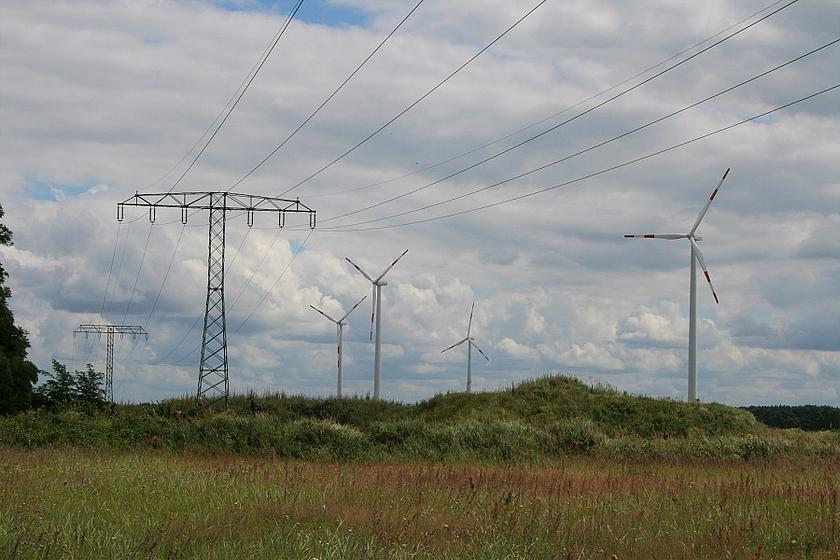 Windräder und Stromnetze in grüner Landschaft
