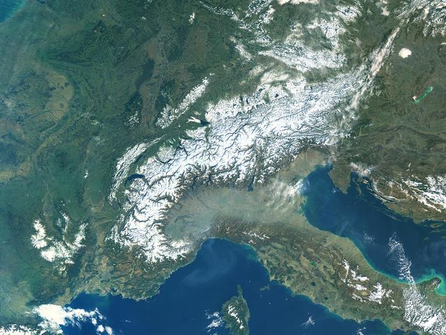 Satellitenbild von Bergen und einer Landschaft davor, die grau verschleiert ist.