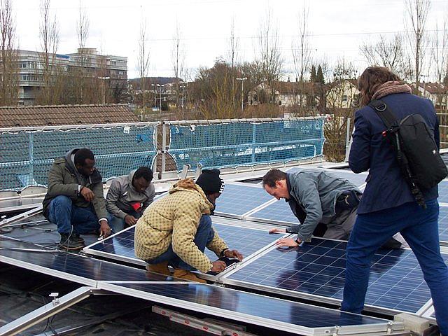 Mitarbeiter zeigen Asylbewerbern mit Montage- und elektrotechnischer Berufserfahrung den Umgang mit der Solartechnik. (Foto: © Claus Scheuber Projektentwicklung- Konzeptdesign)