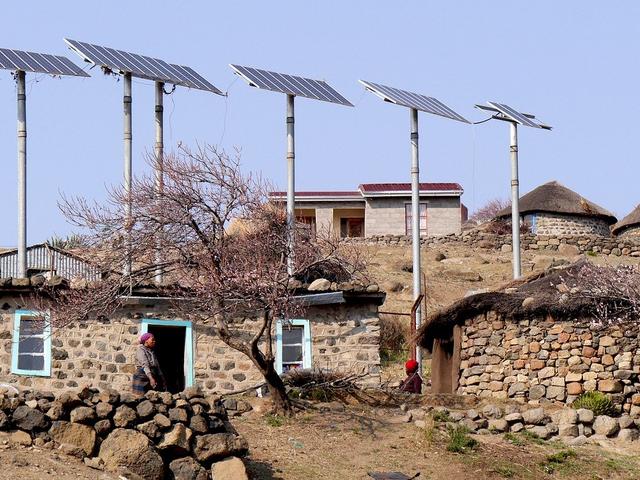 Über flachen Steinhäusern erheben sich Solaranels