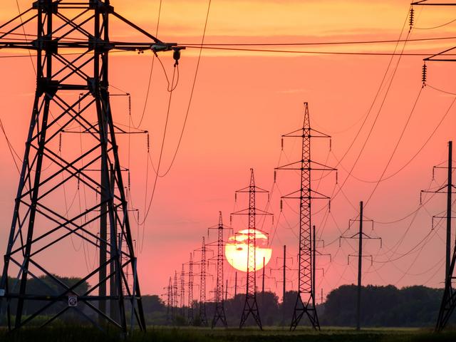 Hochspannungsleitung mit Strommasten im Sonnenuntergang