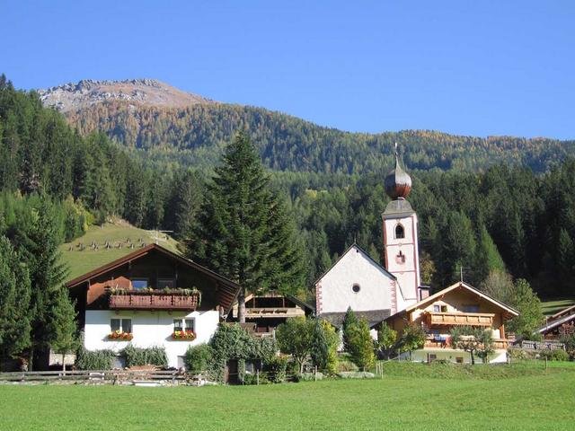 Privathäuser in Kärnten, kleine Kirche im Hintergrund Berg