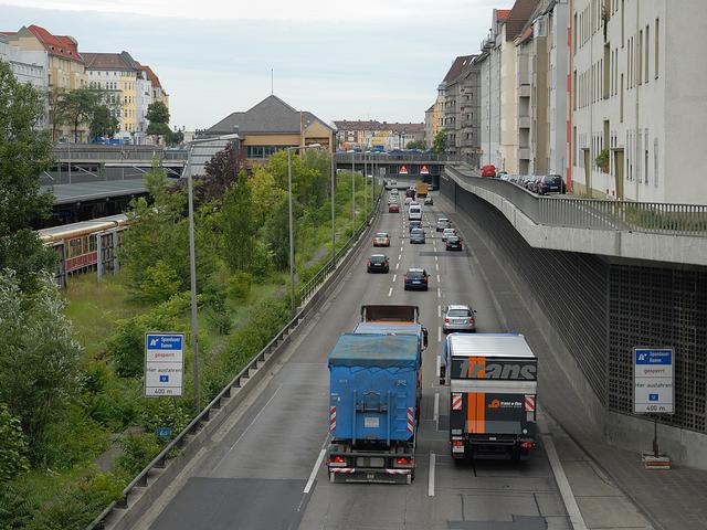 Eine Autobahn mitten in der Stadt. Rechts Häuser, Links die S-Bahn.
