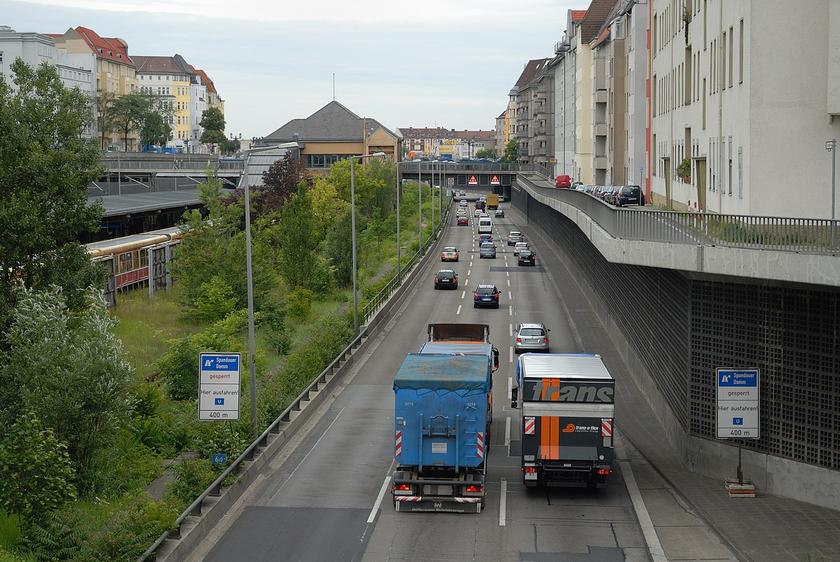 Eine Autobahn mitten in der Stadt. Rechts Häuser, Links die S-Bahn.