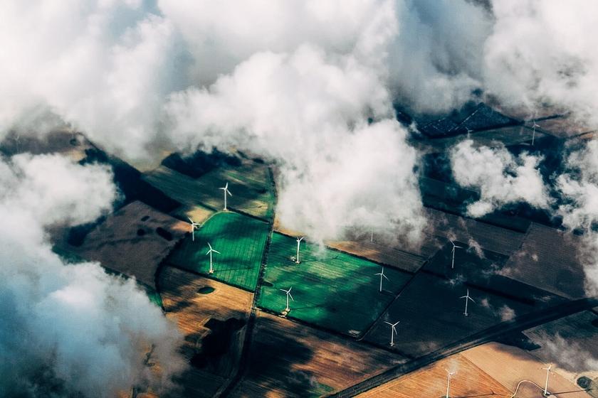 Windräder auf Feldern mit Wolkendecke aus der Vogelperspektive