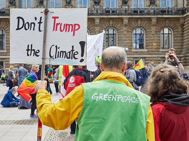 Mann auf Demo mit Protestschild, auf dem steht "Don´t Trump the climate"