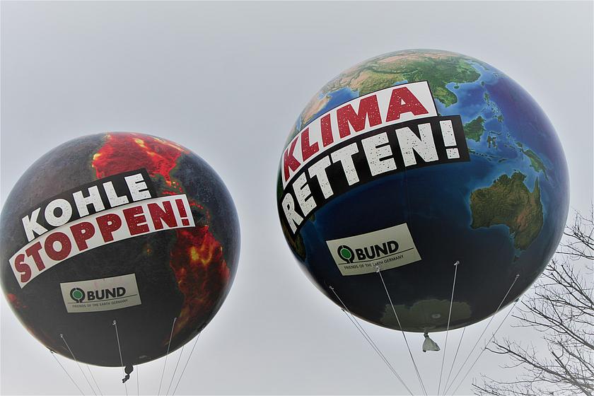 Luftballons auf einer Demo mit Aufschrift "Raus aus der Kohle" und "Klima retten"