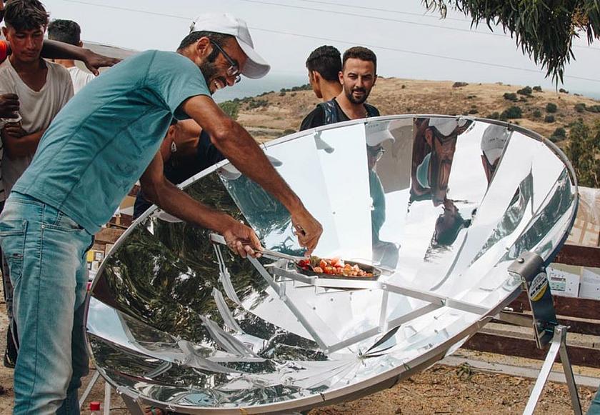 Menschen vor einem Solarkocher