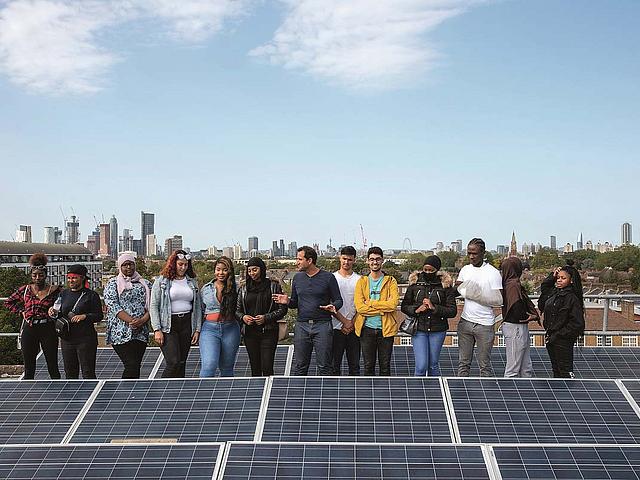Junge Menschen auf einem Dach mit Solaranlage