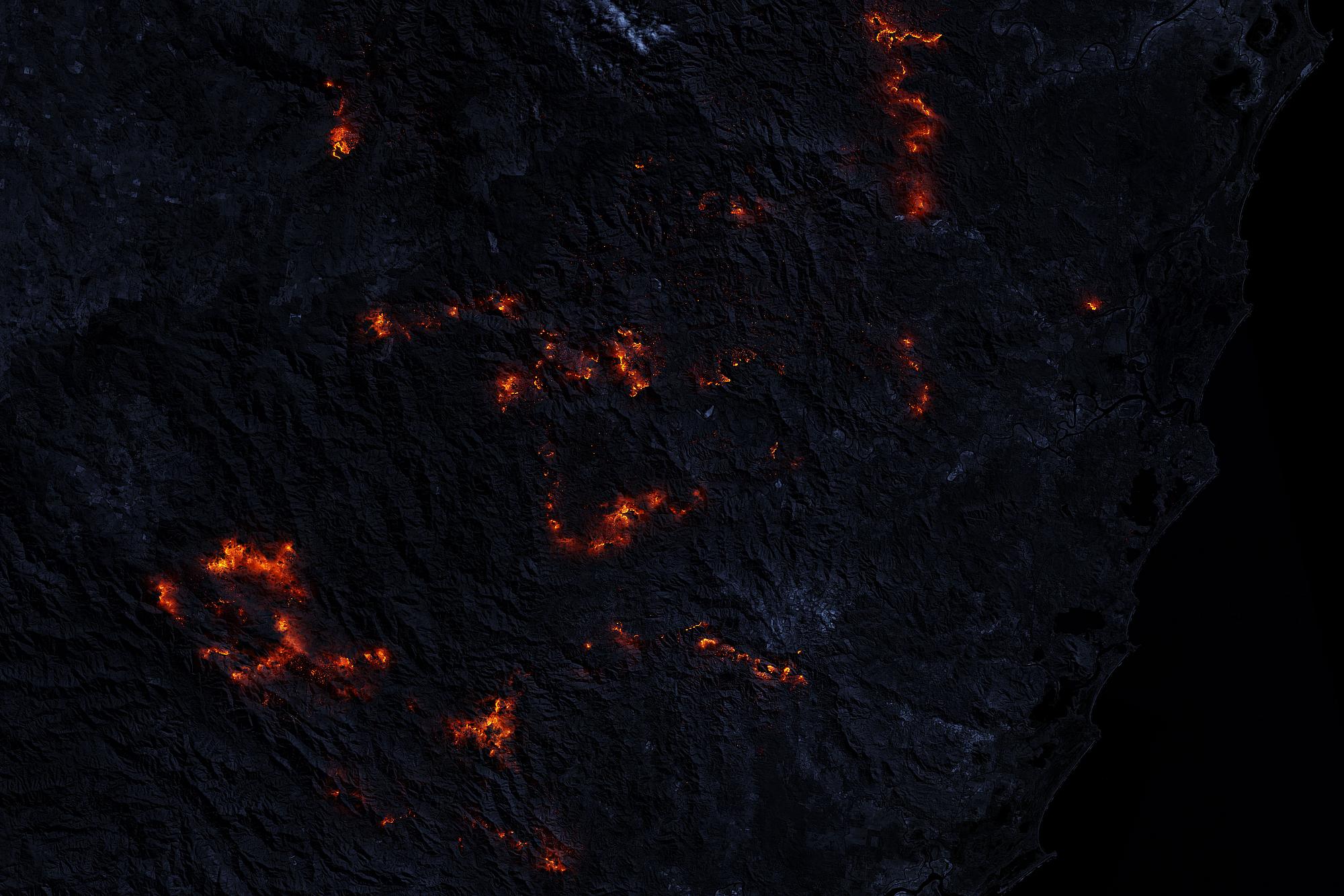 Satellitenbild bei Nacht. Zu sehen sind die Brandherde von Feuern in Australien.
