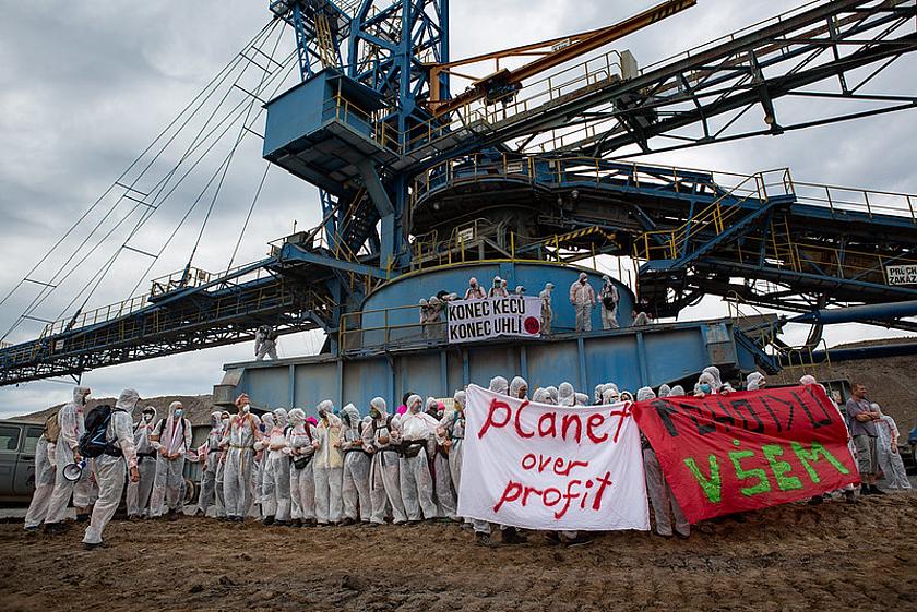 Klimaaktivsten in weißen Maleranzügen und Bannern besetzen einen Kohlebagger