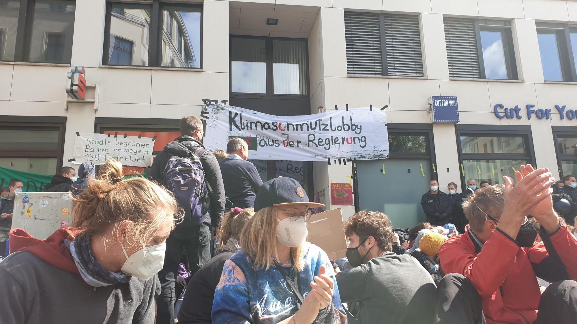 Protestierende am Wirtschaftsrat der CDU vor einem Banner mit der Aufschrift "Klimaschmutzlobby raus aus der Regierung"