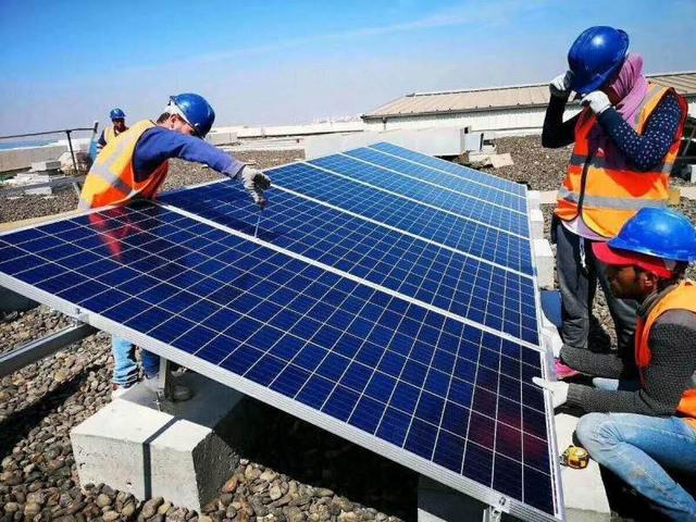 Arbeiter installieren Solaranlage auf Flachdach