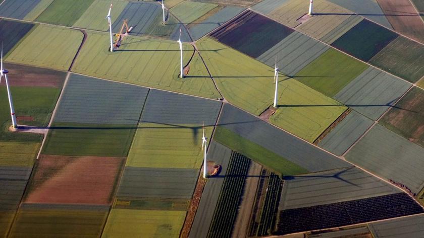 Blick aus der Luft auf Felder und Windkraftanlagen 