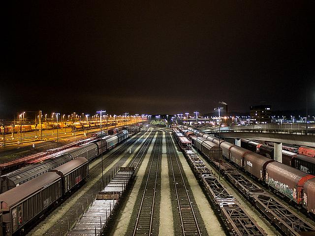 Rangierbahnhof Maschen bei Nacht. Güterwaggons auf Schienen, angestrahlt von Lampen.