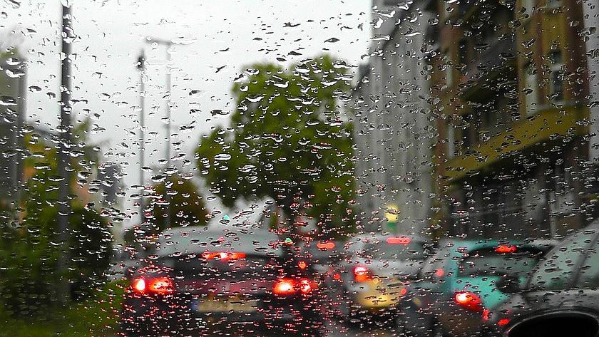 Blick auf den Straßenverkehr aus einem Auto bei Regen.
