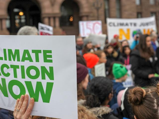 Plakat mit Aufschrift „Climate Action now“ 