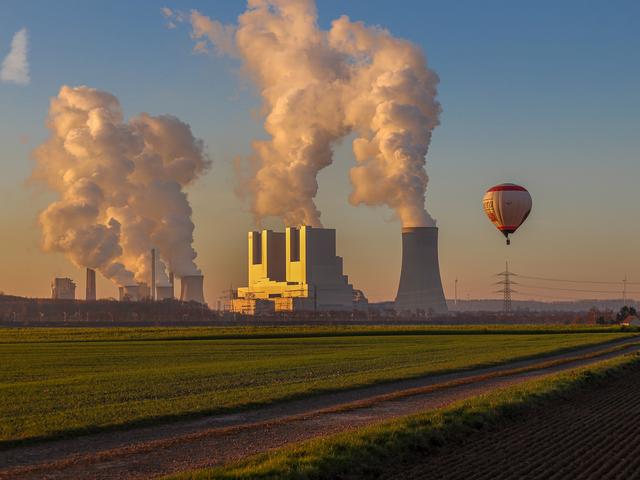 Braunkohlekraftwerk Neurath und Heißluftballon in der Abendsonne