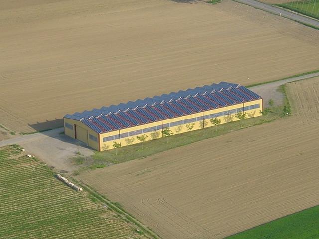 Haus mit Solardach zwischen Feldern