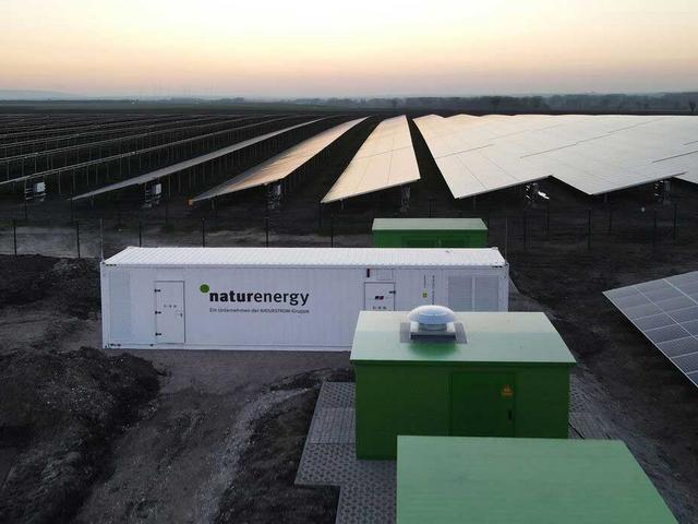 Solarpark mit Container-Energiespeicher im Abendlicht