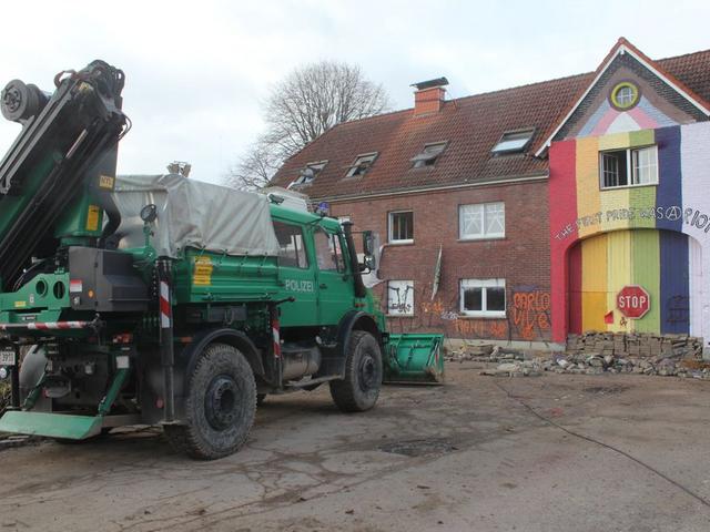 Polizeiauto vor einem von Aktivist:innen besetzten Haus in Lützerath
