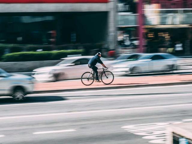 Fahrradfahrer inmitten von Autoverkehr
