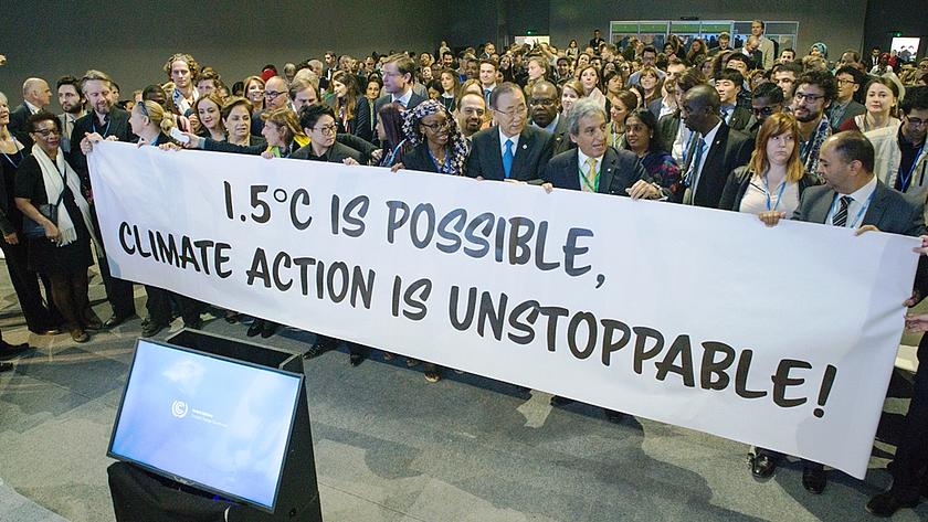 Abschied von Ban Ki-moon als UN-Generalsekretär, Ban Ki-moon in der Menschenmenge mit einem Plakat mit der Aufschrift „1,5 ° Celsius ist possible, Climate Action is unstoppable“