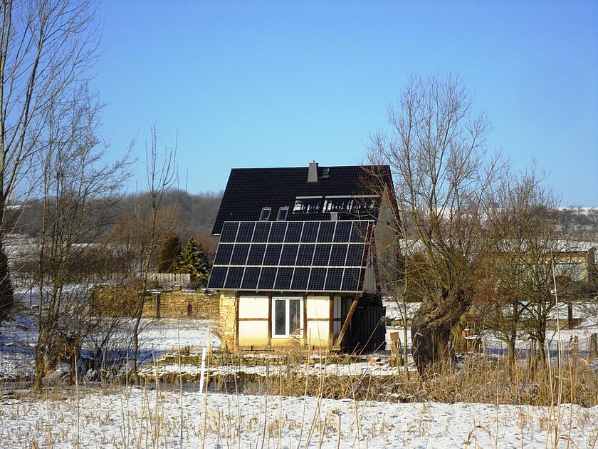 Einfamilienhaus mit Solaranlage bei leichtem Schnee