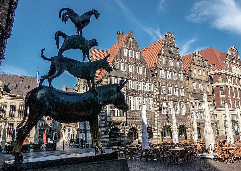 Bild einer Statue der Bremer Stadtmusikanten, bestehend aus Esel, Hund, Katze und Hahn, die übereinandergereiht vor dem Bremer Rathaus stehen.