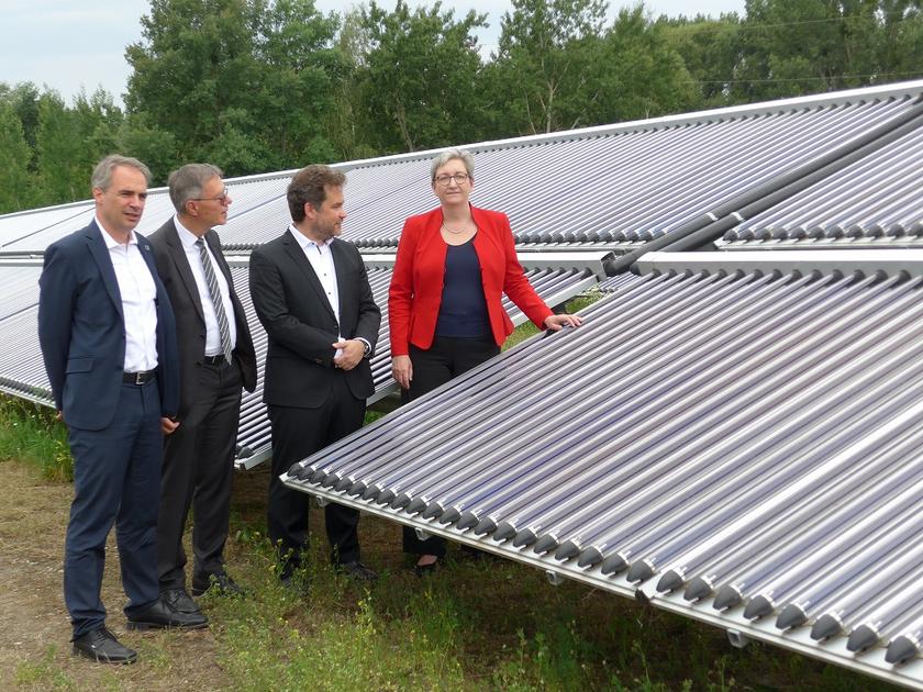 Carsten Körnig (BSW), Burkhard Exner (Stadt Potsdam), Moritz Ritter (Ritter Energie- und Umwelttechnik) und Bundesbauministerin Klara Geywitz (SDP) vor der solarthermischen Freiflächenanlage in Potsdam.