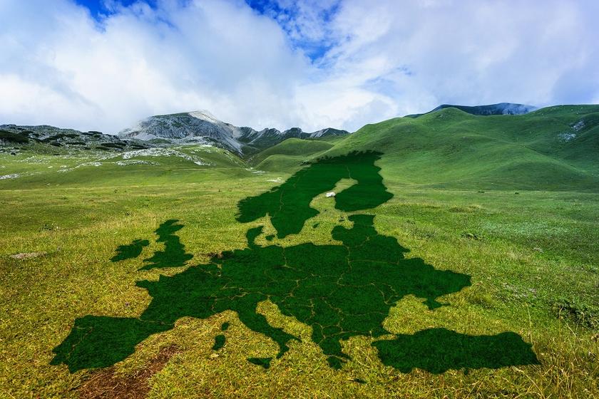 Schatten in Form einer Europa-Karte auf einer grasbewachsenen Hügellandschaft