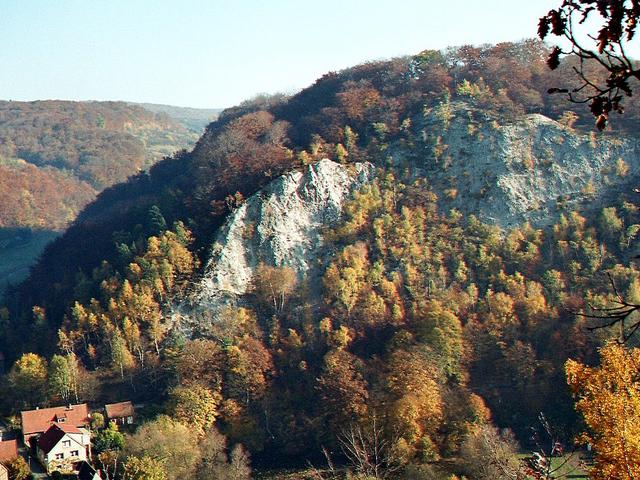 Berg mit Bäumen bewachsen, weißes Gestein sichtbar