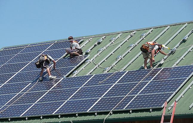 Solarmodule werden auf einem großflächigen Hausdach installiert