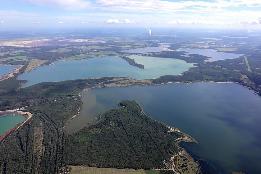 Luftaufnahme einer Landschaft mit Seen und Tagebauen und Kohlekraftwerken im Hintergrund