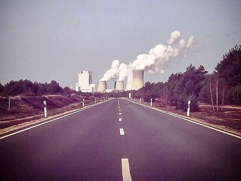 Straße mit Kohlekraftwerk im HIntergrund